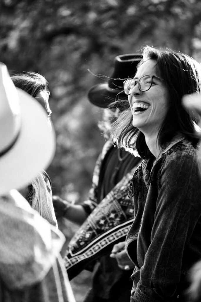Group of adults enjoying laughter and interaction at an outdoor event.